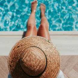 a woman wearing a hat while in a pool